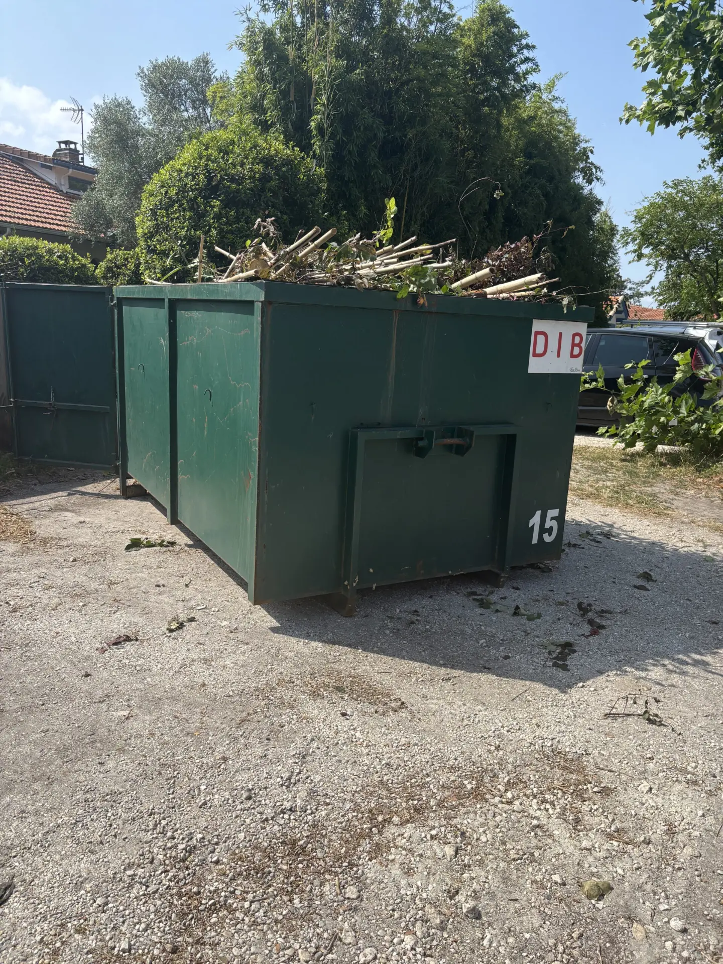 Benne verte remplie de branchages et de déchets végétaux